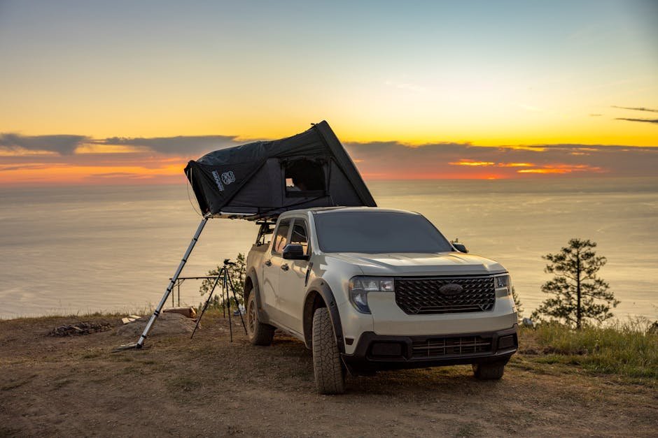 Stunning sunset view of an off-road vehicle with a rooftop tent by the ocean, perfect for adventure camping.